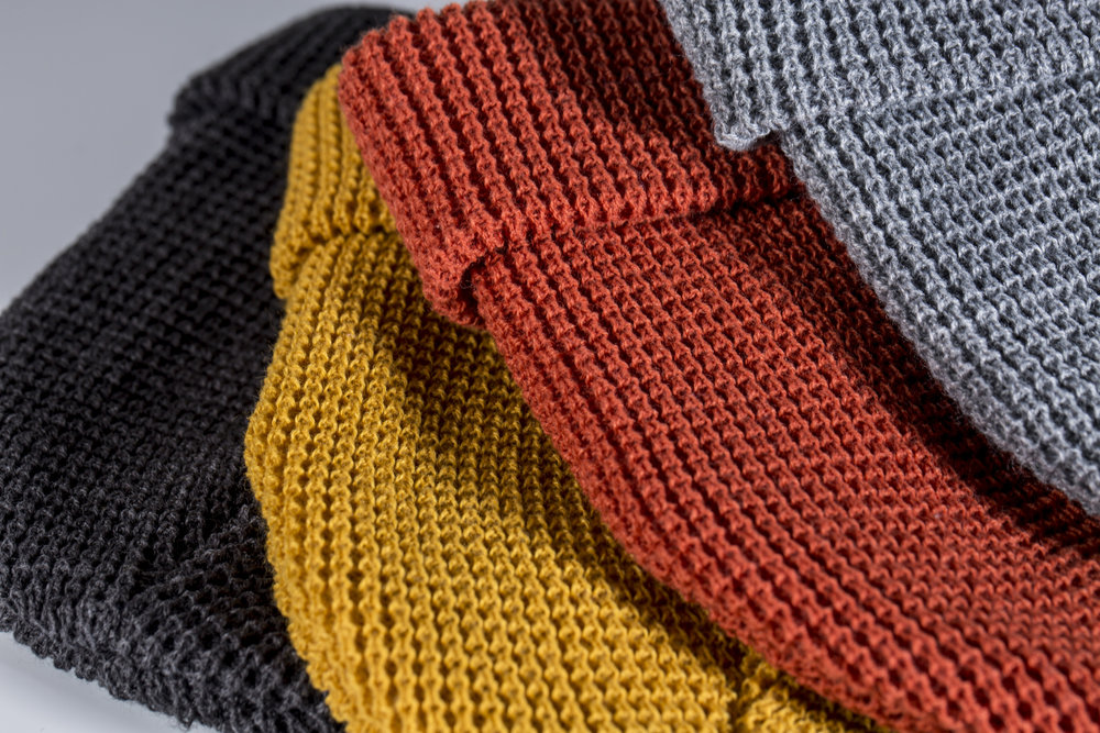 A heather charcoal wheat and rust waffle knit folded beanies showing thread detail